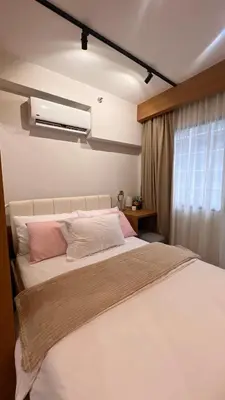 a bedroom with a large white bed with pink pillows at Lemmon's Casita in Manila