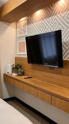a large flat screen tv on a wooden shelf at Lemmon's Casita in Manila
