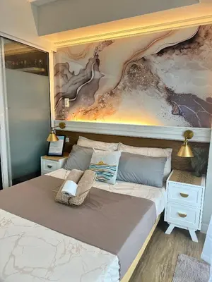 a bedroom with a large bed with a painting on the wall at Azure Urban Beach Residences with PS4 near Airport in Manila