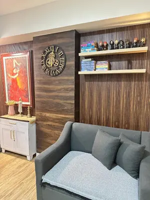 a living room with a couch and a clock on a wall at Azure Urban Beach Residences with PS4 near Airport in Manila