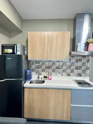 a kitchen with a sink and a black refrigerator at Azure Urban Beach Residences with PS4 near Airport in Manila