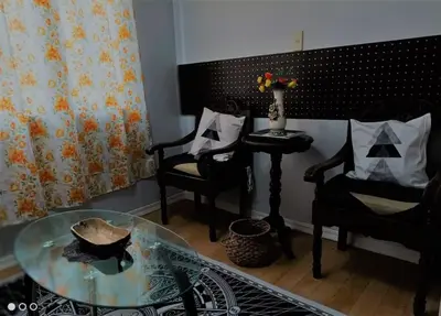 a living room with two chairs and a glass table at Royal loft with breakfast options in Cainta