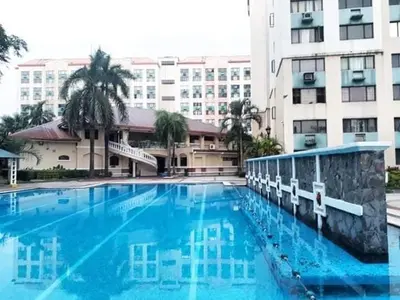 a large blue swimming pool in front of a building at Royal loft with breakfast options in Cainta