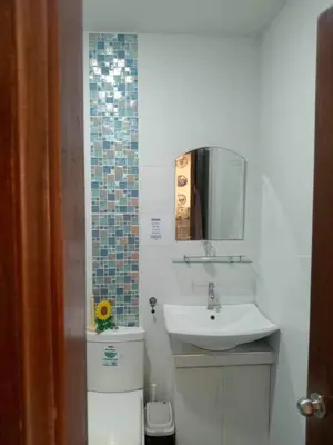 a bathroom with a sink and a toilet and a mirror at Entire house in high end subdivision in Antipolo