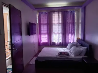 a purple bedroom with a bed and a window at Entire house in high end subdivision in Antipolo