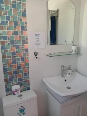 a bathroom with a sink and a toilet and a mirror at Entire house in high end subdivision in Antipolo