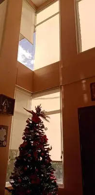 a christmas tree in a room with a window at Entire house in high end subdivision in Antipolo