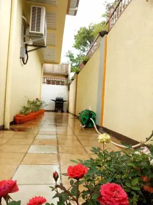 a courtyard of a building with red flowers on the ground at Entire house in high end subdivision in Antipolo