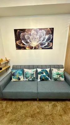 a blue couch with pillows in a living room at The GoodVibes Condotel Red Residences Makati in Manila