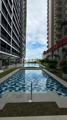 a swimming pool in the middle of two tall buildings at The GoodVibes Condotel Red Residences Makati in Manila