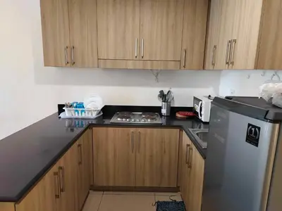 a kitchen with wooden cabinets and a black counter top at Shore Res 2 Br 2Bath 1417 in Manila