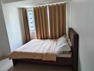 a small bed in a bedroom with a window at Shore Res 2 Br 2Bath 1417 in Manila