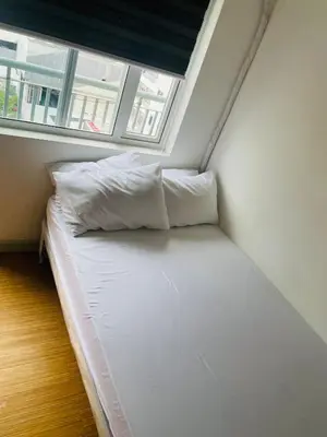 a small bed in a room with a window at SMDC Grace Residences in Manila