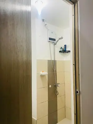 a shower in a bathroom with a light on the wall at SMDC Grace Residences in Manila
