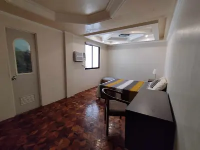 a room with a bed and a table in it at 4-5br Apartment in Paranaque for Staycation in Manila