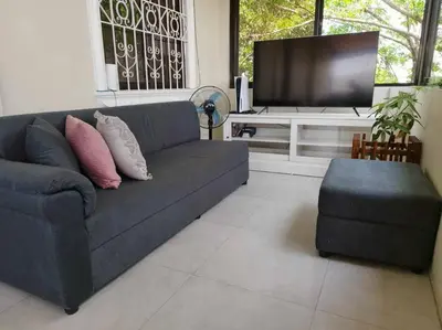 a living room with a couch and a flat screen tv at 4-5br Apartment in Paranaque for Staycation in Manila
