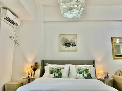 a bedroom with a bed with white sheets and pillows at Bell Place at Venice Luxury Mckinley Hill in Manila