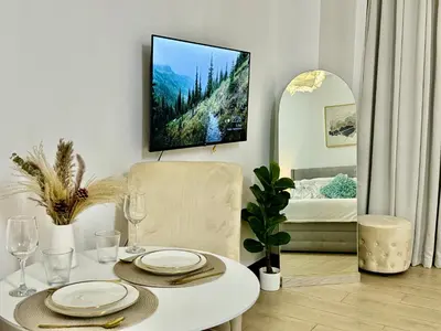 a dining room with a table and a tv on the wall at Bell Place at Venice Luxury Mckinley Hill in Manila