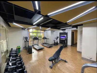 a gym with exercise equipment in a room at Bell Place at Venice Luxury Mckinley Hill in Manila