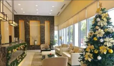 a living room with a christmas tree in a room at 8 Adriatico Manila Condotel Sea View Corner Unit Near St Lukes Clinic in Manila