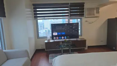 a living room with a couch and a large window at 8 Adriatico Manila Condotel Sea View Corner Unit Near St Lukes Clinic in Manila