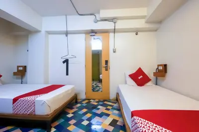 a room with two beds and a mirror at Spot On Junction Hostel in Manila