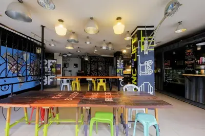 a dining room with tables and chairs and lights at Spot On Junction Hostel in Manila