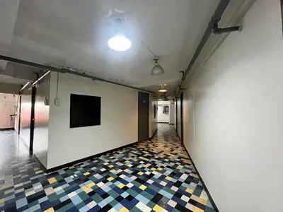 a hallway with a wall with a tv and a tiled floor at Spot On Junction Hostel in Manila