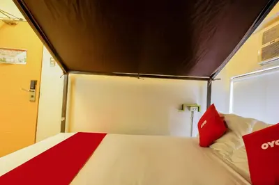 a bedroom with a large bed with red pillows at Spot On Junction Hostel in Manila