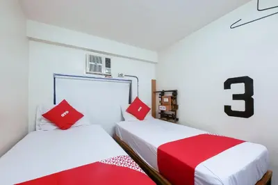 two beds in a room with red and white at Spot On Junction Hostel in Manila