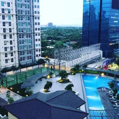 a view of a building with a swimming pool at Cozy 1 BR San Lorenzo Place Netflix 4KM NAIA in Manila