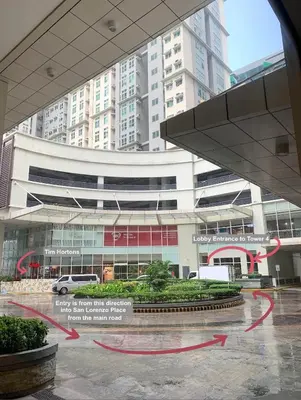 a large building with red arrows in front of it at Cozy 1 BR San Lorenzo Place Netflix 4KM NAIA in Manila
