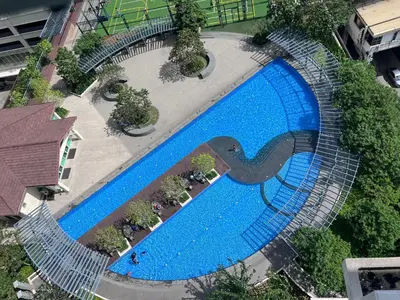 an overhead view of a large blue swimming pool at Cozy 1 BR San Lorenzo Place Netflix 4KM NAIA in Manila