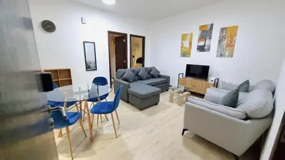 a living room with a couch and a table and chairs at Cozy 2BR 2Bath San Lorenzo Place Netflix 4KM NAIA in Manila