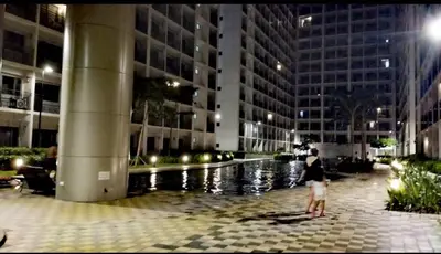 a woman and a child standing in front of a building at E & R Staycation Condotel near Mall of Asia in Manila