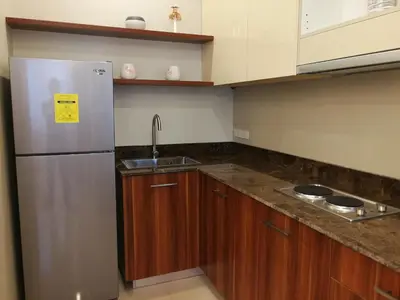 a kitchen with a stainless steel refrigerator and wooden cabinets at Adria Residences - Diamond Garden - 2 Bedroom Unit for 4 Person in Manila