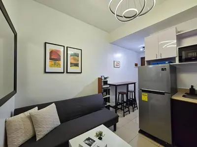 a living room with a couch and a kitchen at 1BR Condotel Ridgewood Towers Taguig City #RW02 in Manila