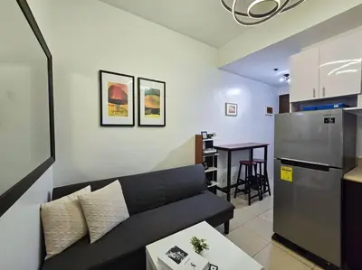 a living room with a couch and a kitchen at 1BR Condotel Ridgewood Towers Taguig City #RW02 in Manila
