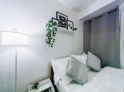 a bedroom with a bed and a plant on the wall at 1BR Condotel Ridgewood Towers Taguig City #RW03 in Manila