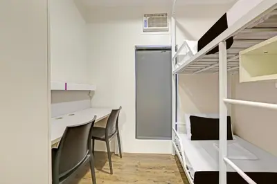 a room with bunk beds and a desk and chairs at Spot On Classy Bunkbeds Near Makati Manila Formerly MYTOWN Madrid in Manila