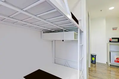 a room with a white closet with a shelf at Spot On Classy Bunkbeds Near Makati Manila Formerly MYTOWN Madrid in Manila