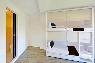 a room with two bunk beds and a bathroom at Spot On Hostel ,Taguig Manila Formerly MYTOWN HongKong in Manila