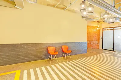 two orange chairs sitting next to a brick wall at Spot On Hostel ,Taguig Manila Formerly MYTOWN HongKong in Manila