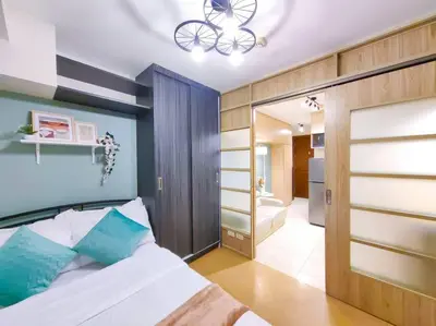 a bedroom with a bed and a chandelier at 1BR Condotel Ridgewood Towers Taguig City #RW06 in Manila