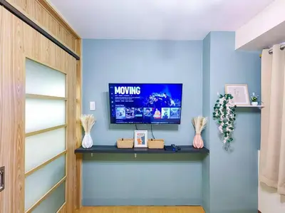 a living room with a tv on a blue wall at 1BR Condotel Ridgewood Towers Taguig City #RW06 in Manila