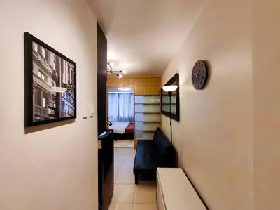 a hallway with a couch and a clock on a wall at 1BR Condotel Ridgewood Towers Taguig City #RW07 in Manila
