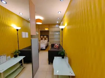 a room with a yellow wall and a living room at 1BR Condotel Ridgewood Towers Taguig City #RW08 in Manila
