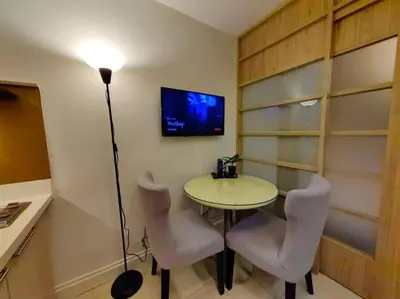 a room with a table and chairs and a tv at 1BR Condotel Ridgewood Towers Taguig City #RW08 in Manila