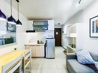 a kitchen and living room with a refrigerator and a table at 1BR Condotel Ridgewood Towers Taguig City #RW09 in Manila