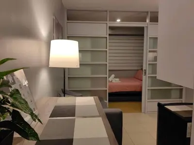 a living room with a table and a bedroom at 1BR Condotel Ridgewood Towers Taguig City #RW10 in Manila